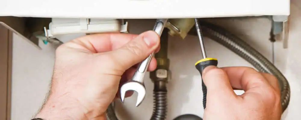 Boiler repair technician tightening pipe fittings and connections in Champaign, IL