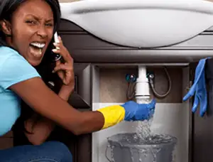 Emergency plumbing repair for a leaking sink drain under a bathroom vanity in Champaign, IL