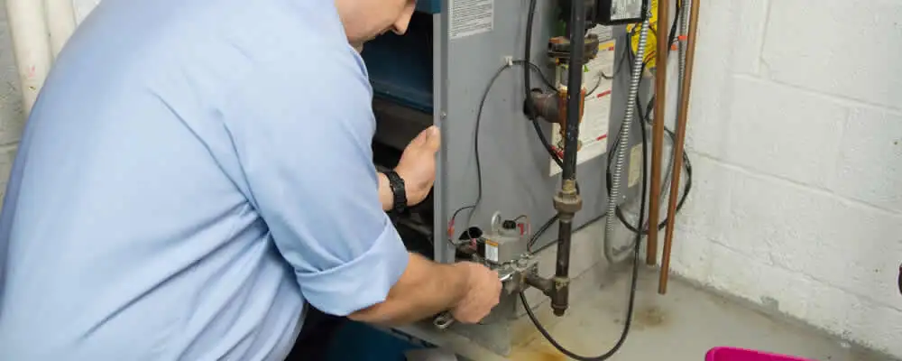 Furnace repair technician inspecting and servicing a home heating system in Champaign, IL