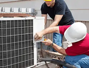 HVAC technicians repairing an outdoor AC unit on a rooftop in Champaign, IL