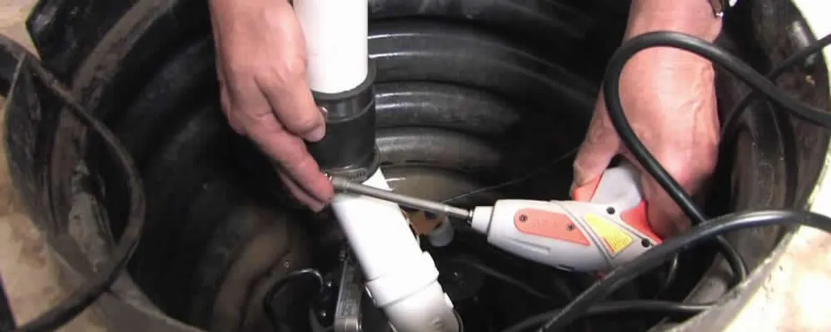 Sump pump installation technician connecting PVC discharge piping in Champaign, IL
